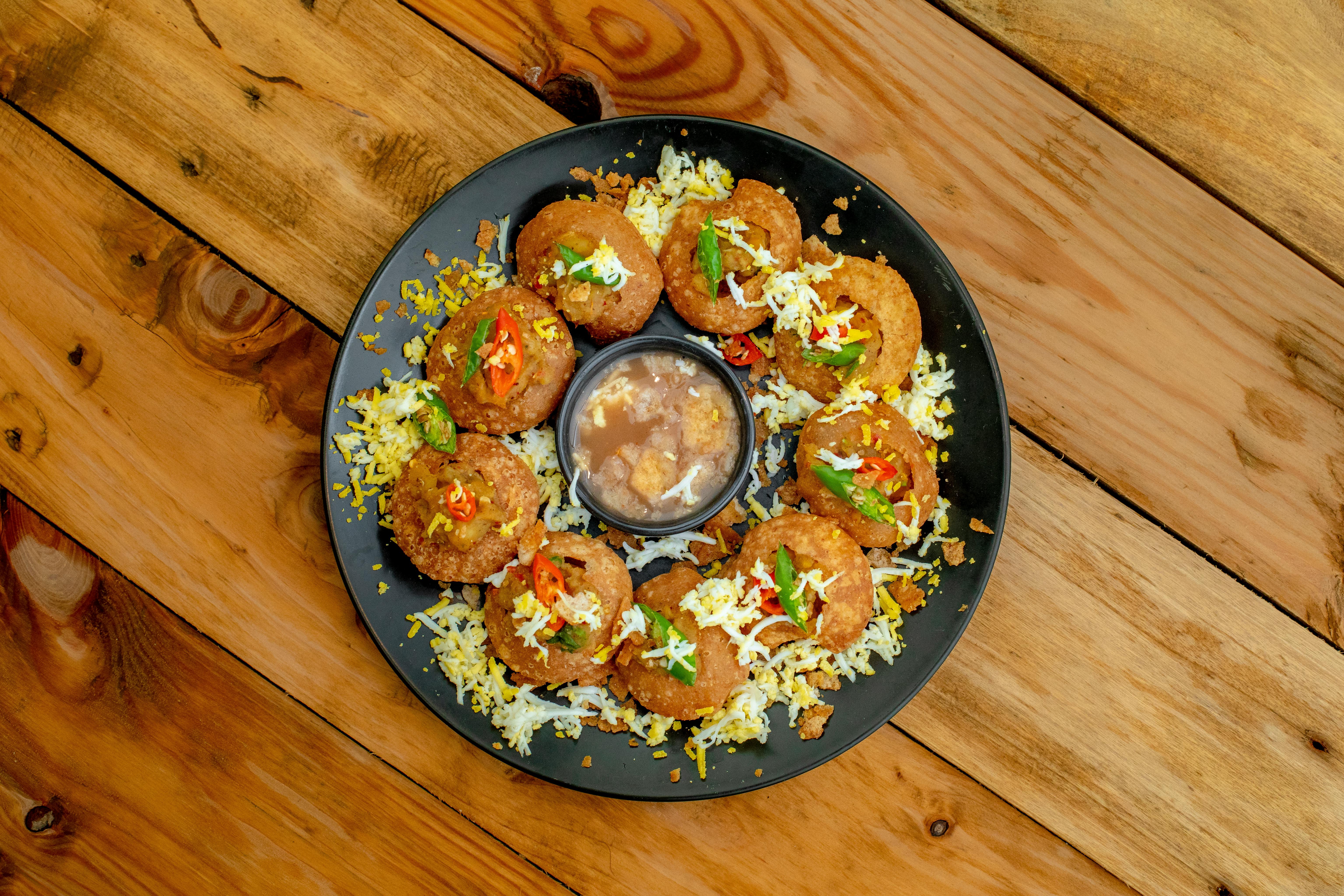 Top view of a traditional Indian Pani Puri platter with chutney, showcasing vibrant and colorful Indian street food.